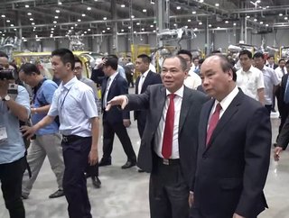Phạm Nhat Vuong showing Vietnam's former President Nguyen Xuan Phuc around the VinFast plant in 2019